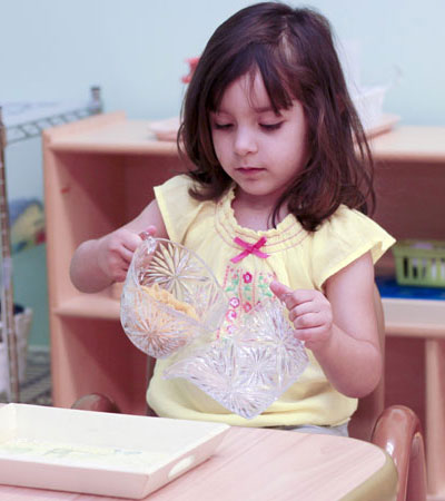 young girl pouring fluids from one pitcher to another